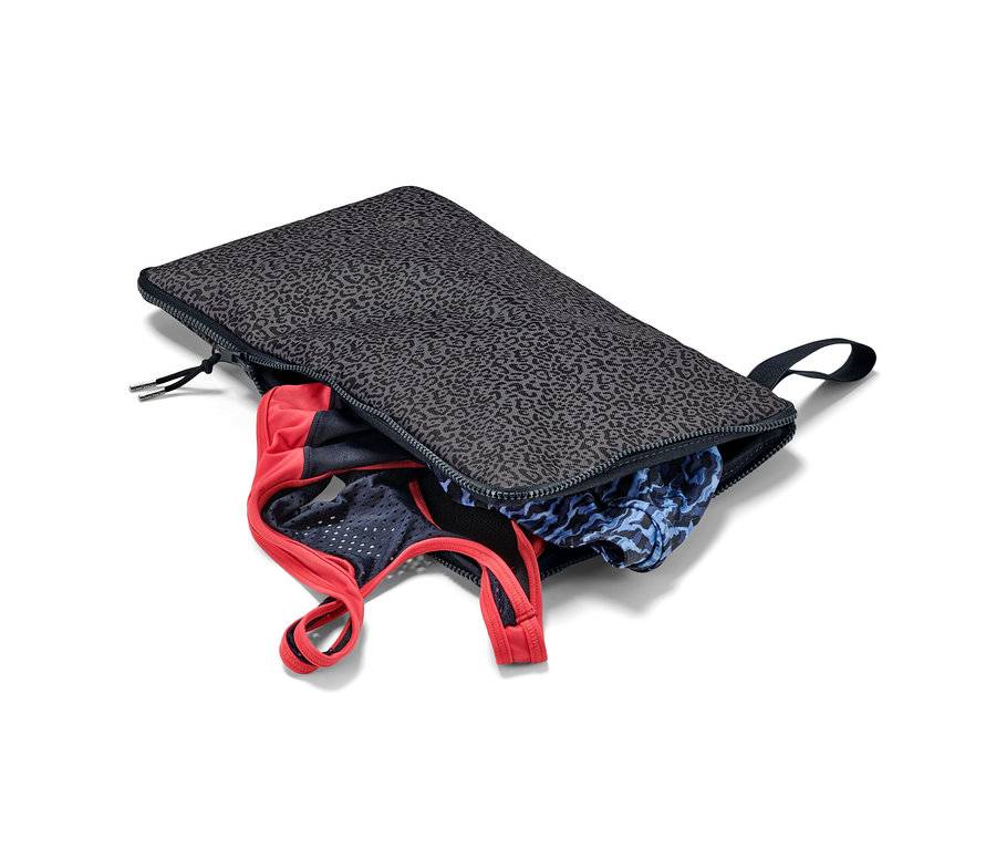 Un sac à linge humide et support pour se changer 2 en 1 ouvert avec des vêtements à l'intérieur.