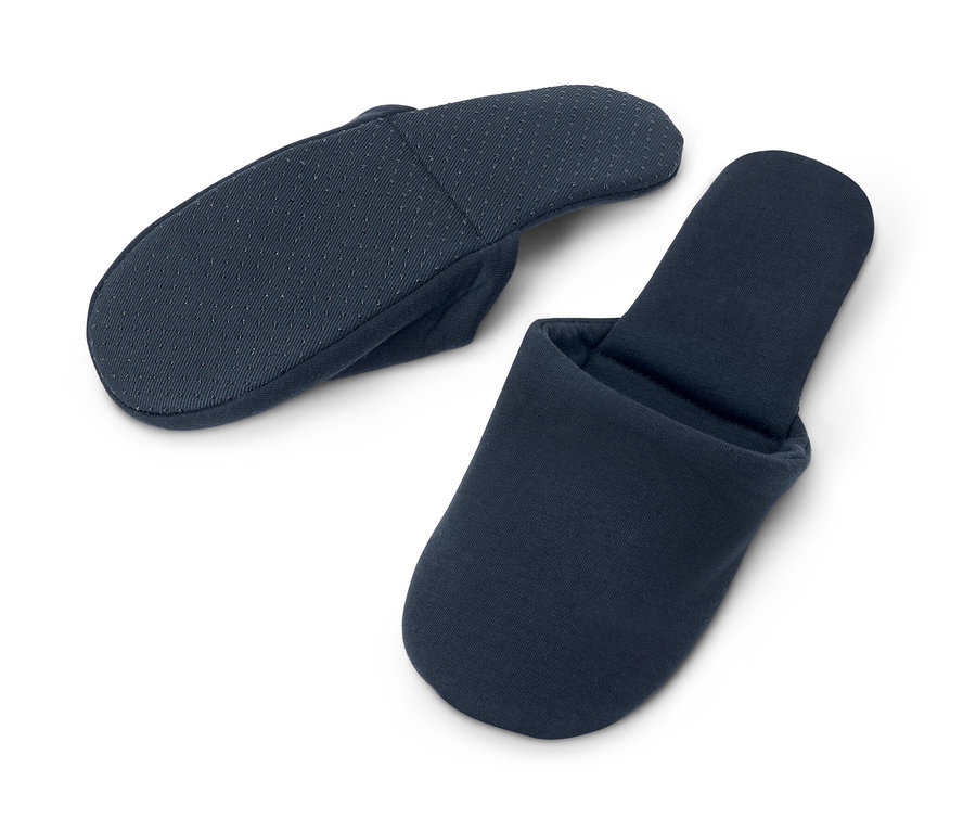 Deux paires de pantoufles de voyage bleu marine sont posées sur un fond blanc.