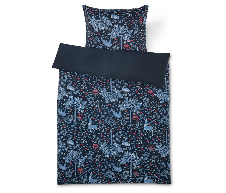 Linge de lit avec motif de forêt et d'animaux sur fond bleu foncé.