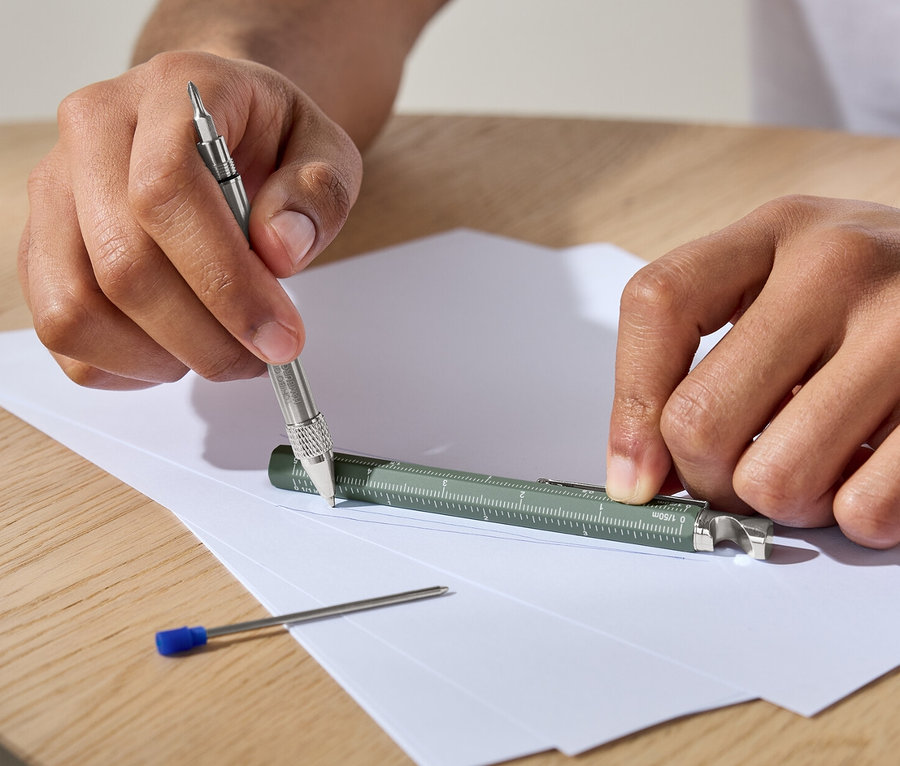 Un homme utilise un stylo multifonction sur du papier.