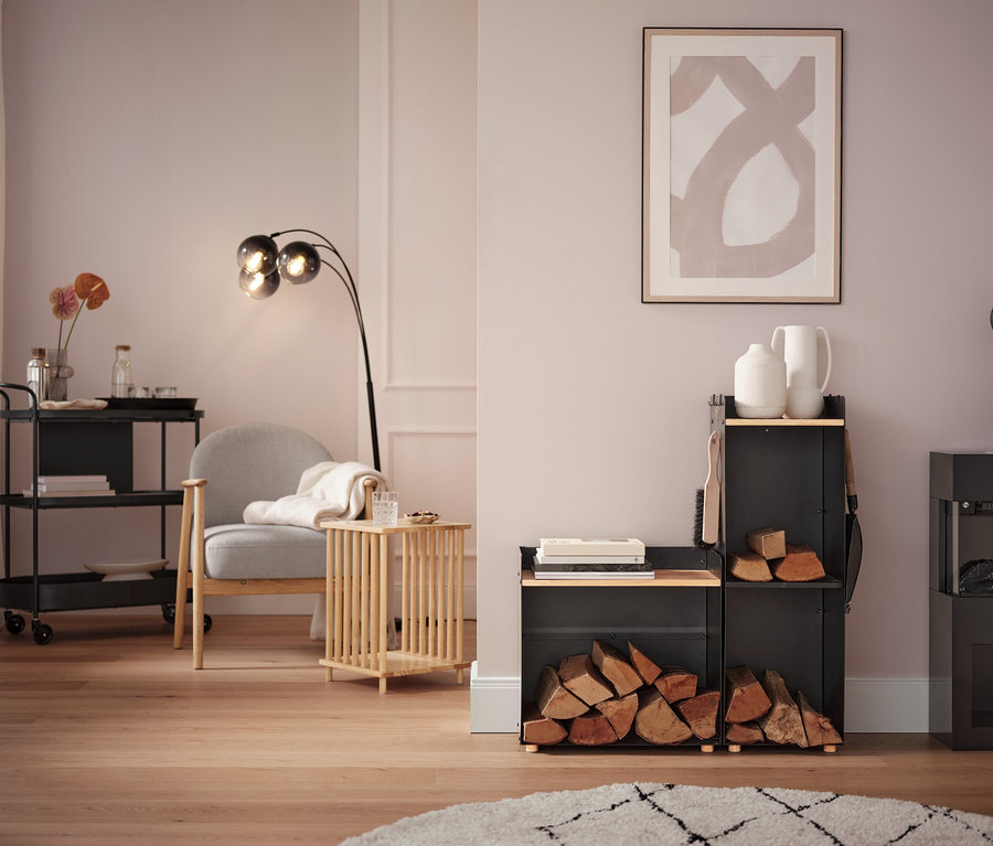 Salon avec fauteuil gris, lampadaire et desserte à roulettes.