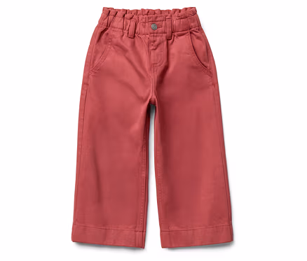 Un pantalon rose à taille haute et jambes larges posé sur un fond blanc.