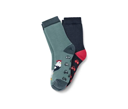 Deux paires de chaussettes antidérapantes pour tout petit, ferme : une paire verte avec un coq, une paire bleu foncé avec des tracteurs.