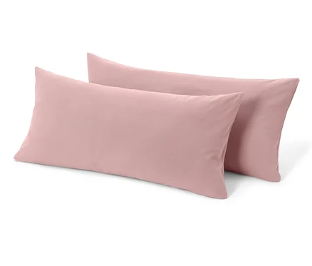Deux taies d’oreiller en jersey rose sont posées l’une sur l’autre.