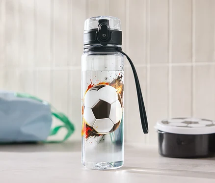 Une bouteille d'eau avec un motif de ballon de football est posée sur une table.