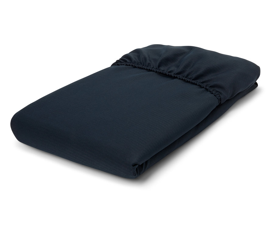 Drap-housse bleu marine plié sur fond blanc.