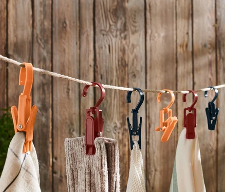 Divers tissus suspendus à une corde à linge avec 6 clips d’extérieur.