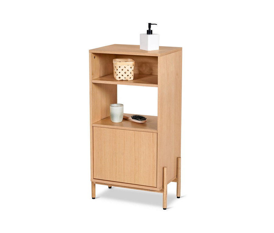 Une armoire de salle de bain avec placage bois a deux étagères ouvertes, l'étagère du haut contient une pompe blanche et un panier, l'étagère du bas contient une tasse et une brosse.