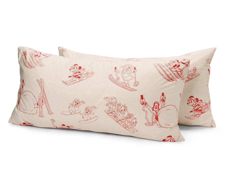 Deux oreillers blancs avec des personnages de dessins animés rouges de souris faisant du ski.