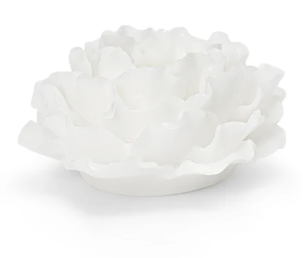 Bougie décorative blanche en forme de fleur sur fond blanc.