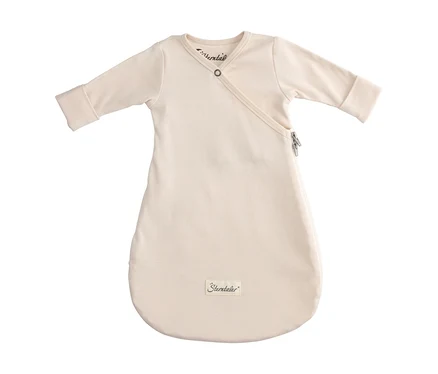 Gigoteuse bébé crème à manches longues, fermeture portefeuille en haut avec bouton-pression et fermeture éclair latérale. Le logo "Sterntaler" est visible en bas.