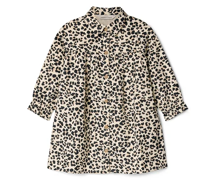 Une robe chemise beige pour enfant avec un imprimé léopard noir, un col, des boutons sur le devant et des manches longues froncées.