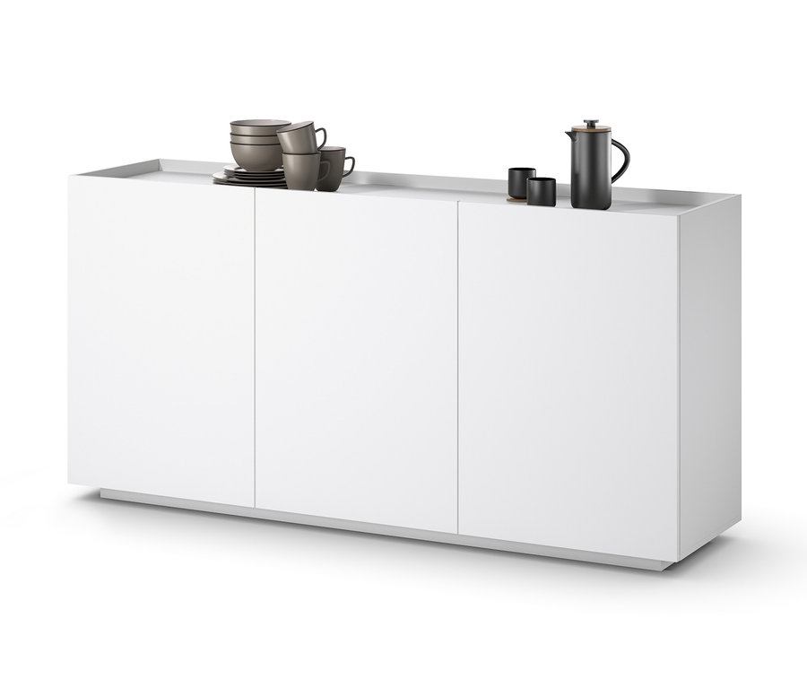 Un buffet blanc avec trois portes. Des tasses et une cafetière sont posées sur le buffet.