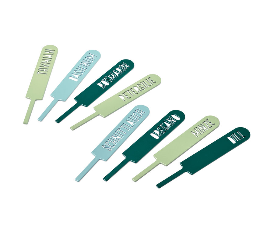 Huit étiquettes d'herbes aromatiques reposent sur un fond blanc.