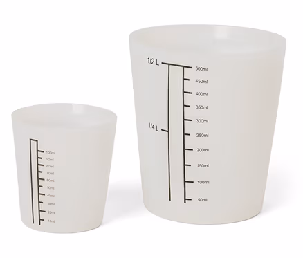 Deux tasses à mesurer blanches de différentes tailles avec des marques noires.