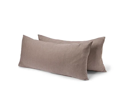 Deux oreillers rectangulaires marron mat en tissu doux et texturé, l'un légèrement derrière l'autre.
