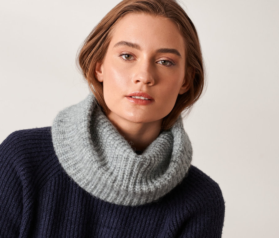 Femme portant une écharpe tube tricotée.