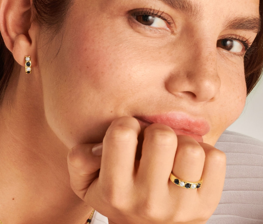 Femme portant une bague Noir et Blanc, une chaîne et des créoles Noir et Blanc.