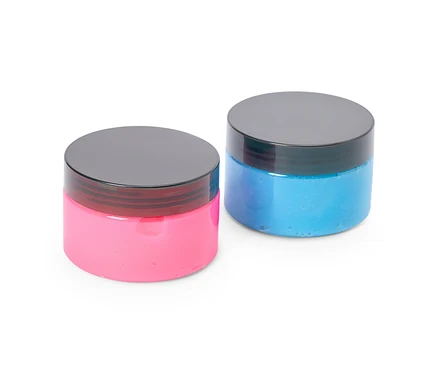 Deux pots ronds et translucides avec des couvercles noirs, l'un contenant de la pâte gluante rose et l'autre de la pâte gluante bleue, sont côte à côte sur un fond blanc.