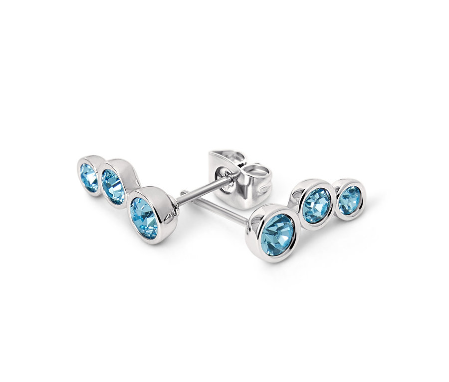 Gros plan de clous d’oreille argentés de couleur aigue-marine.