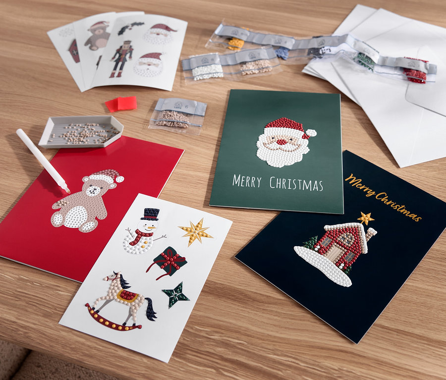 Cartes de vœux de Noël étalées avec des motifs d'ours en peluche, de Père Noël, de bonhomme de neige et de maison.