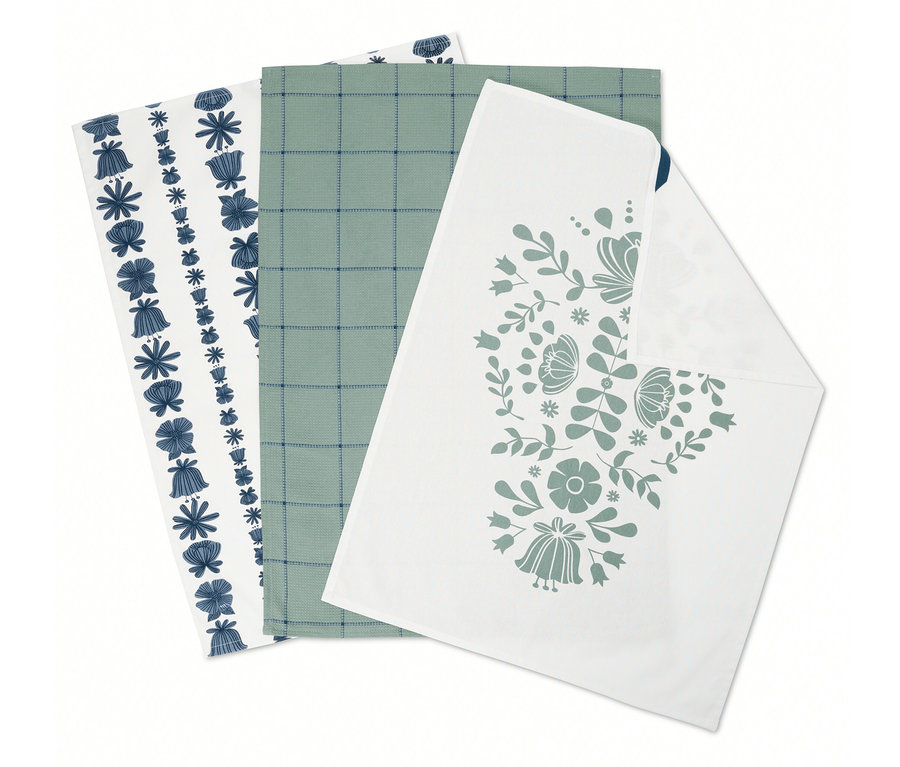Trois torchons pliés : un avec des fleurs bleues, un avec un motif à carreaux verts et un avec un motif floral.