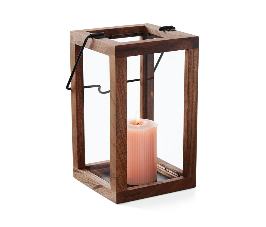 Une bougie rose brûle à l'intérieur d'un photophore en bois et en verre.