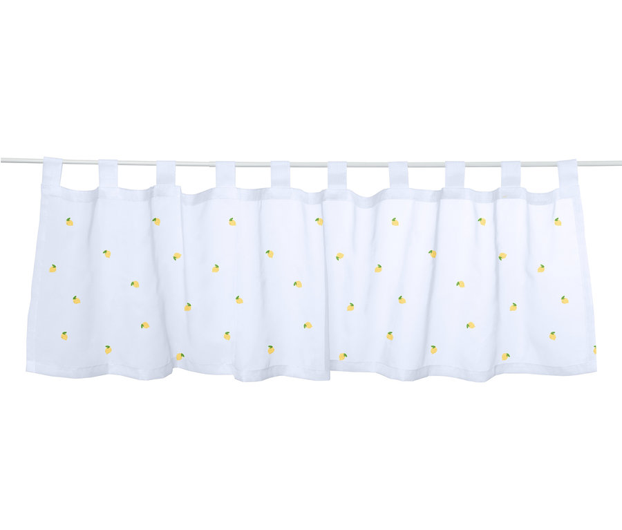 Un brise-bise brodé blanc avec un motif de citrons suspendu à une tringle.