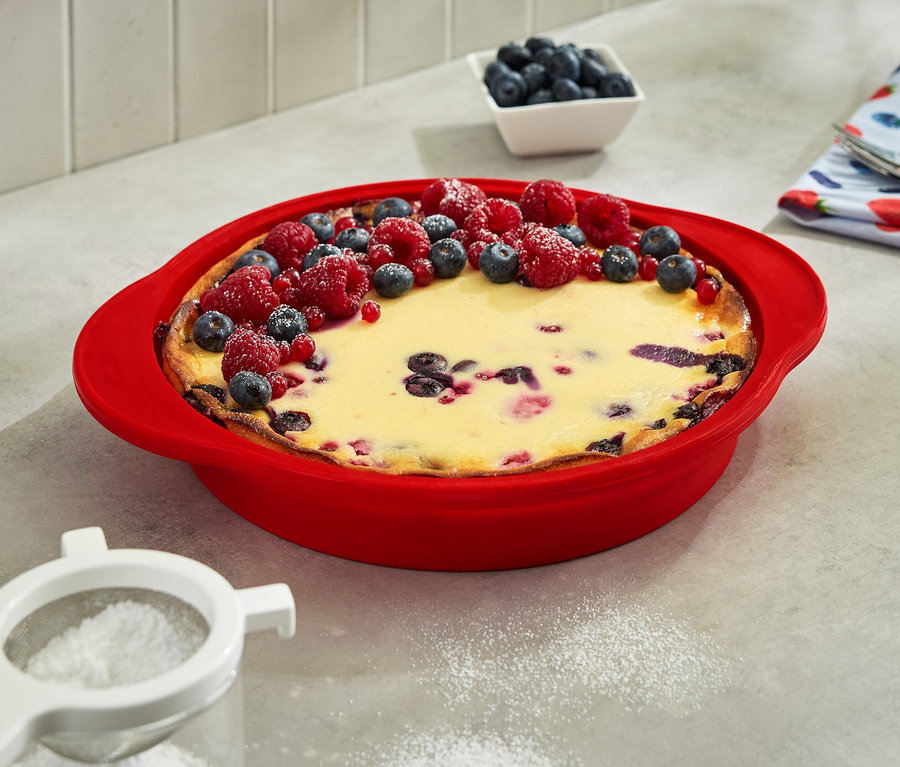 Gâteau dans un moule à gâteau pliable, garni de myrtilles et de framboises.