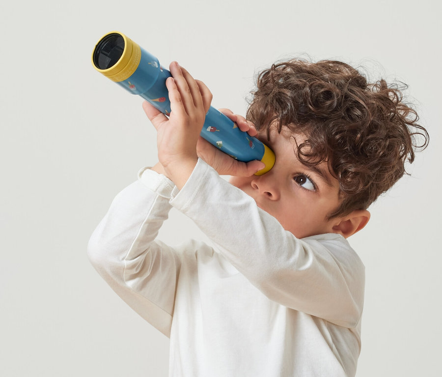 Garçon regardant à travers un jouet-lunette d’approche.