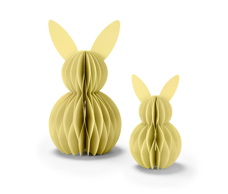 Deux lapins de Pâques en papier jaunes se tiennent l'un à côté de l'autre.