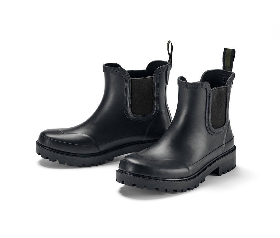 Deux bottines de pluie noires sur fond blanc.