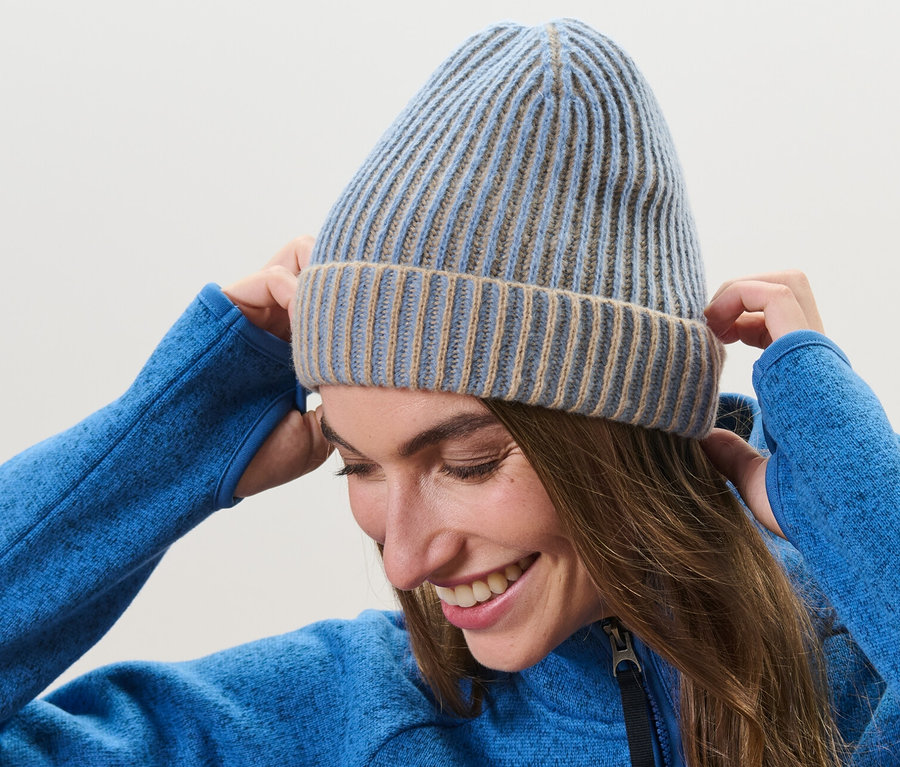 Femme ajustant un bonnet en maille sur sa tête.