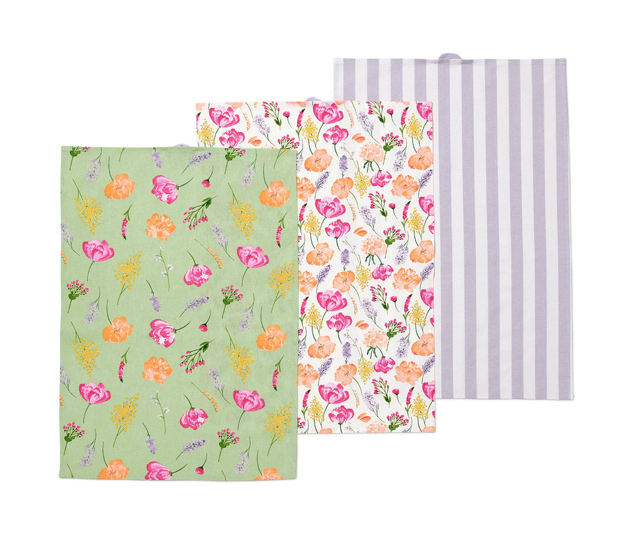 Trois torchons : un vert à motif floral, un à fleurs et un blanc à rayures violettes.