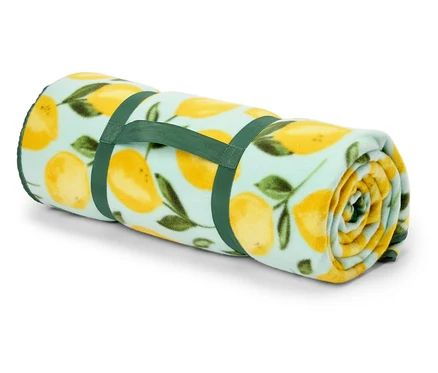 Une couverture bleu clair enroulée avec un motif de citrons, maintenue par deux sangles vertes.