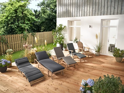 Plusieurs chaises longues de jardin et un fauteuil de jardin Adirondack avec repose-pieds extensible en bois sont disposés sur une terrasse en bois.