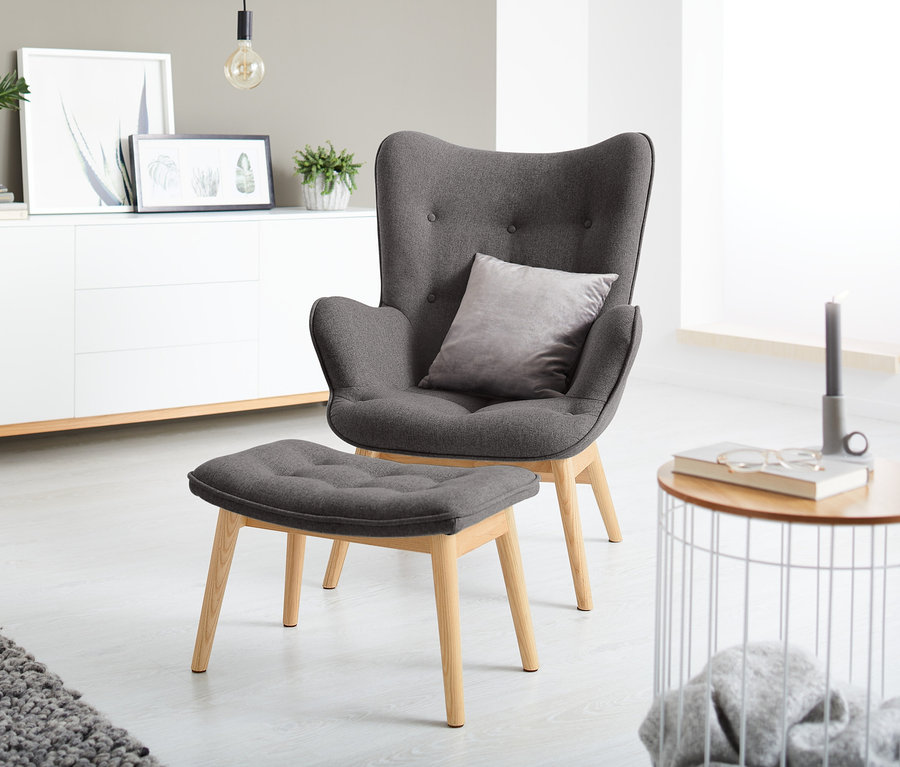 Fauteuil individuel gris foncé avec repose-pieds.