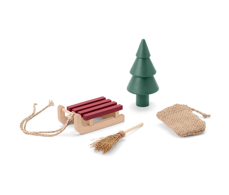 Traîneau, arbre, balai et sac, accessoires pour porte de lutin, sont posés sur un fond blanc.