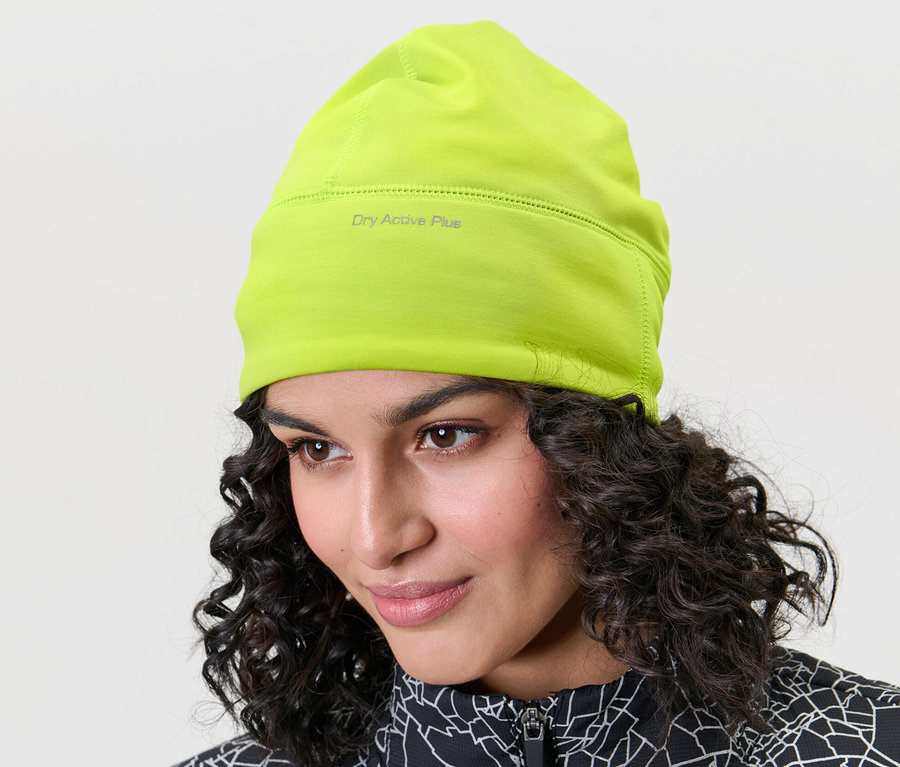 Femme portant un bonnet technique thermique, vert fluo.