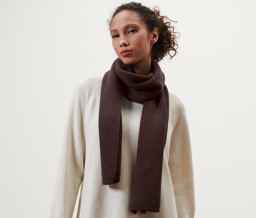 Femme portant une écharpe en maille marron.