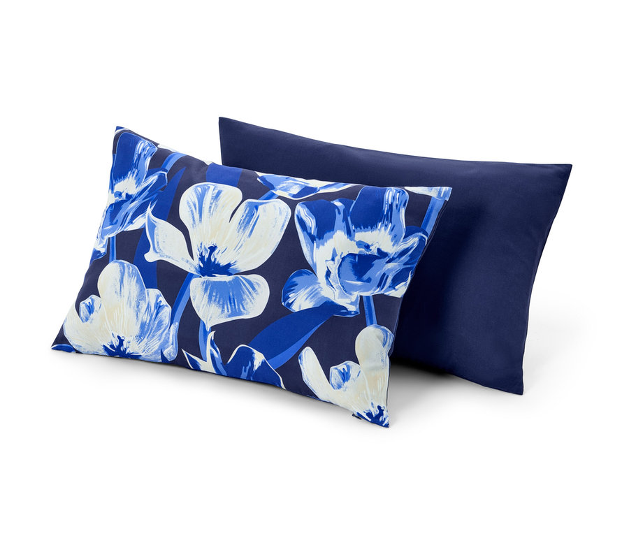 Deux housses de coussin décoratif : une à motif floral et l’autre bleu marine.