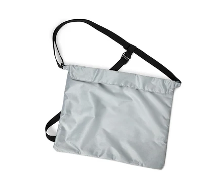 Prise de vue verticale d'un sac à provisions pour vélo argenté avec des sangles noires sur un fond blanc.