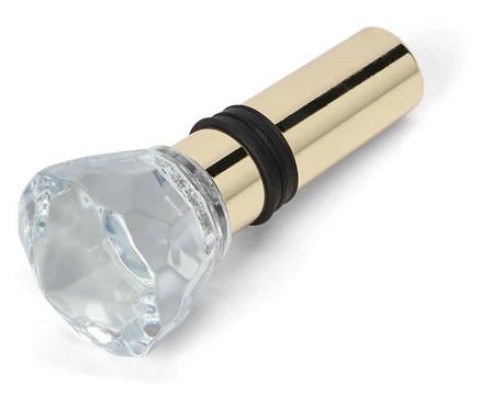 Bouchon de bouteille avec ornement en verre en forme de diamant et base en métal doré.