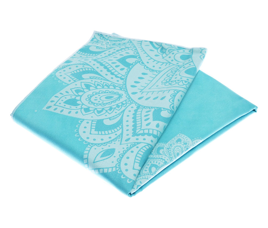 Serviette turquoise pliée avec un motif ornemental blanc.