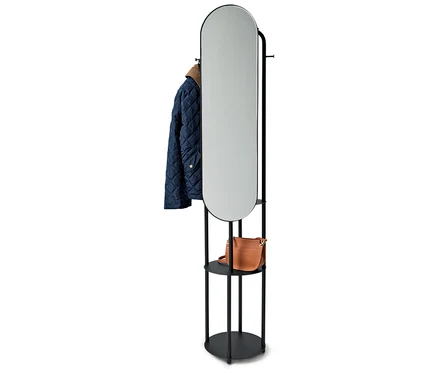 Support noir avec miroir ovale, une veste bleue et un sac à main marron.
