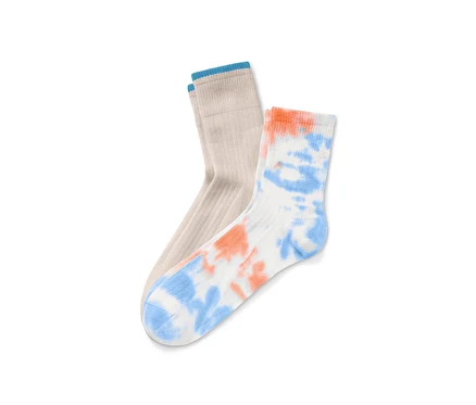 Deux paires de chaussettes : une paire beige avec une bordure bleue et une paire blanche avec un motif tie and dye orange et bleu.