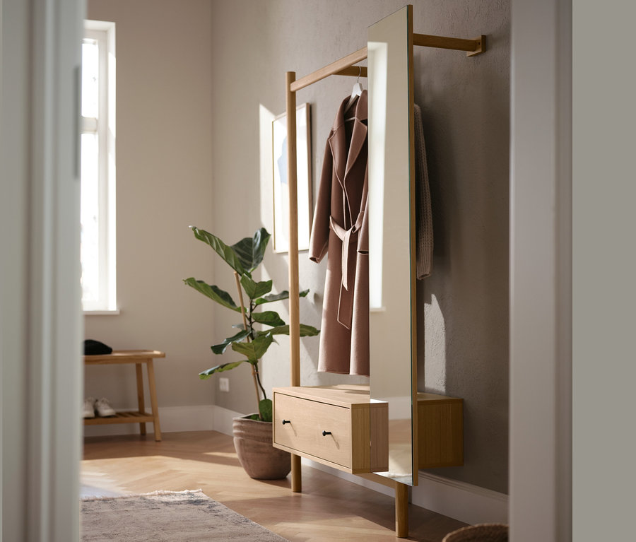 Hall d'entrée avec une garde-robe avec miroir et un manteau.