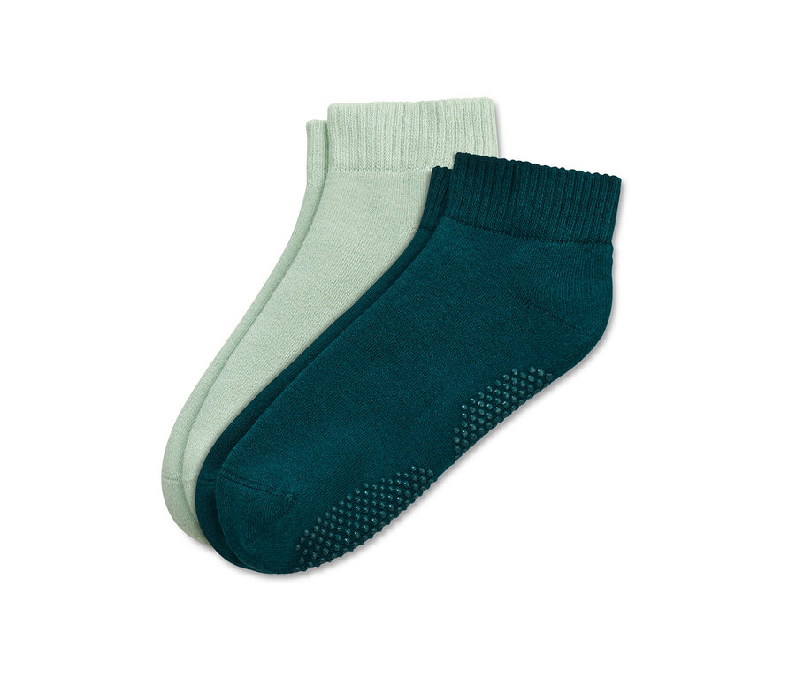 Deux paires de chaussettes de yoga vertes.