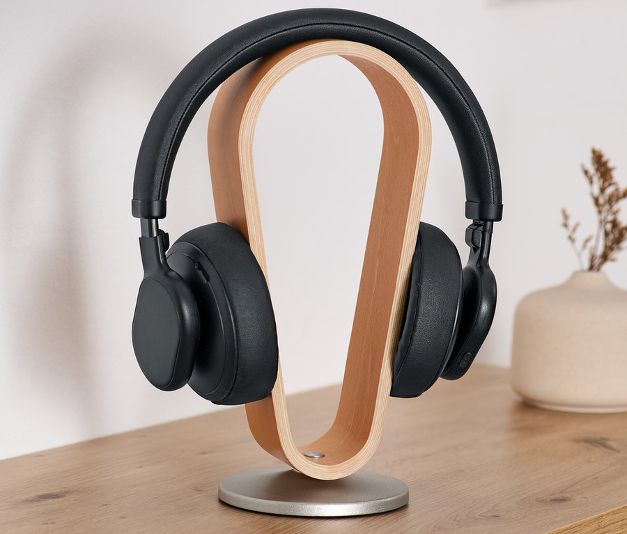 Casque noir sur un support de casque en bois.