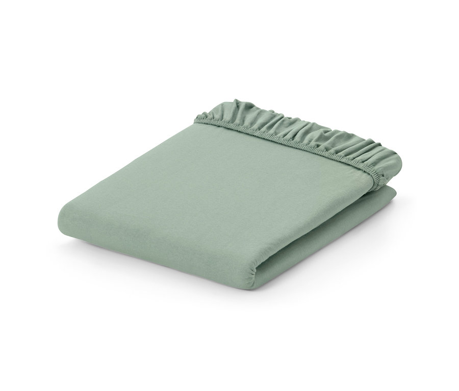 Drap-housse en jersey vert sauge plié.